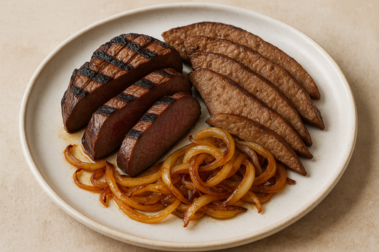 grilled and sliced beef heart along with thinly sliced pan cooked beef liver and sauted onions arranged on a plate